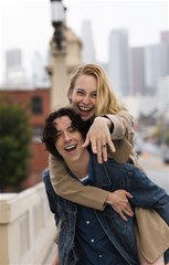 happy couple posing outdoors city with engagement ring